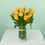 Classic dozen yellow rose bouquet wrapped elegantly with fresh green fillers and ribbon, perfect for birthday celebrations, anniversaries, and cheerful gifting moments.