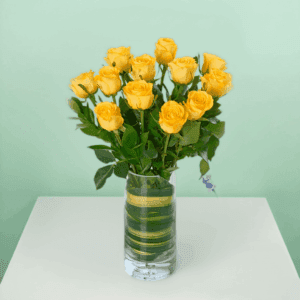Classic dozen yellow rose bouquet wrapped elegantly with fresh green fillers and ribbon, perfect for birthday celebrations, anniversaries, and cheerful gifting moments.