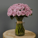 Hand-tied, bunch of purple roses in a glass cylinder vase