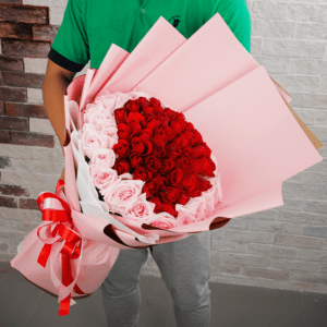 Elegant pink and red roses bouquet wrapped in pink tissue floral wraps and tied with pink and red ribbon