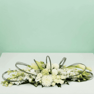 White long and low floral arrangement featuring elegant white roses, orchids, hydrangeas, and seasonal blooms in a modern centerpiece design for weddings, events, and luxury table décor.