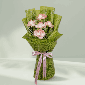 A Bouquet of 5 pink roses with eucalyptus leaves in green wrap tied up in a pink ribbon
