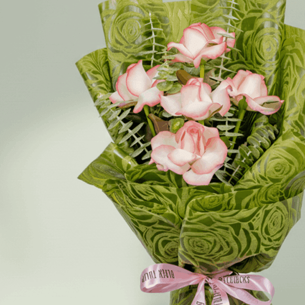 A Bouquet of 5 pink roses with eucalyptus leaves in green wrap tied up in a pink ribbon