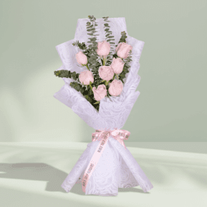Pink rose and eucalyptus bouquet wrapped in soft floral non-woven paper