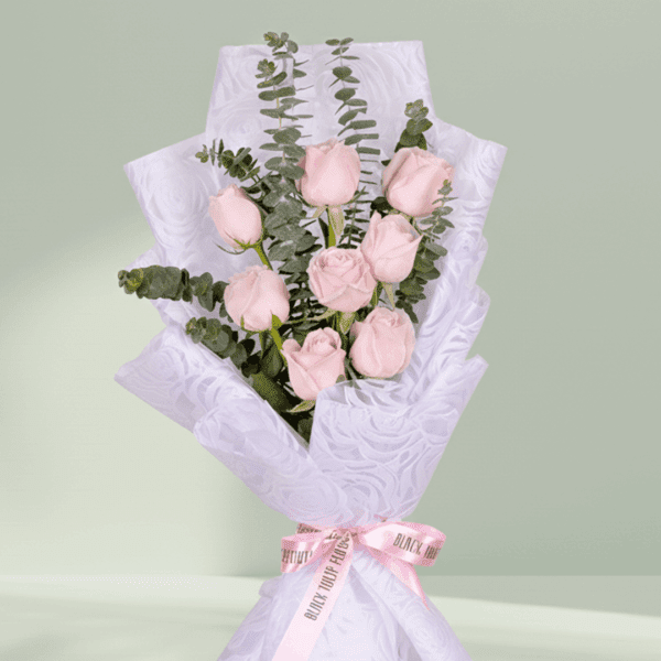 Pink rose and eucalyptus bouquet wrapped in soft floral non-woven paper