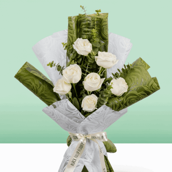 A Bouquet of 7 white roses wrapped in green and white paper.
