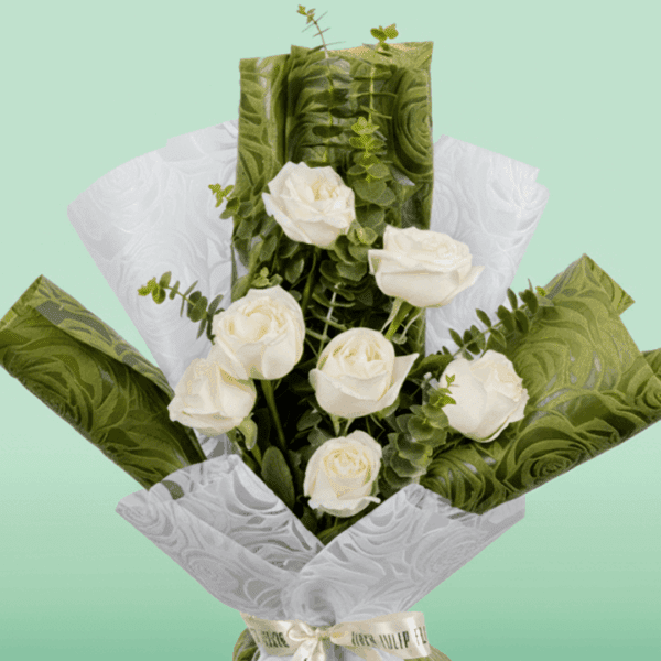 A Bouquet of 7 white roses wrapped in green and white paper.
