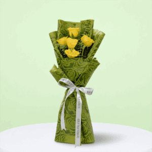 A Bouquet of 5 yellow roses bouquet with green wrap tied up in a pink ribbon