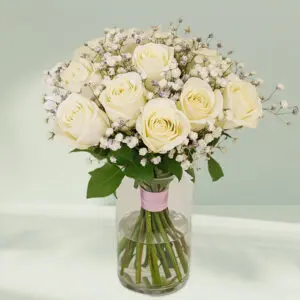 Glass transparent vase with white roses and baby’s breath