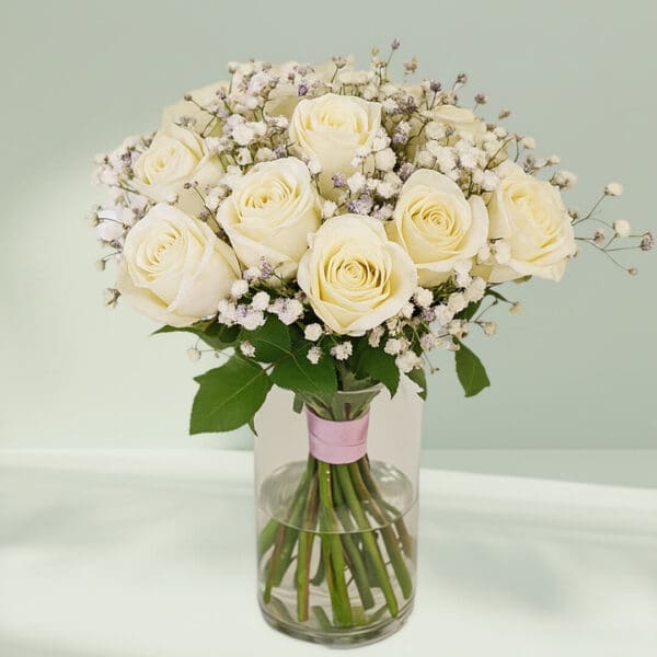 Glass transparent vase with white roses and baby’s breath