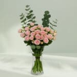 A bunch of romantic rose and eucalyptus in a glass vase