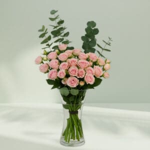 A bunch of romantic rose and eucalyptus in a glass vase