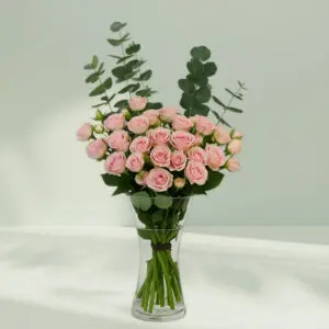 A bunch of romantic rose and eucalyptus in a glass vase