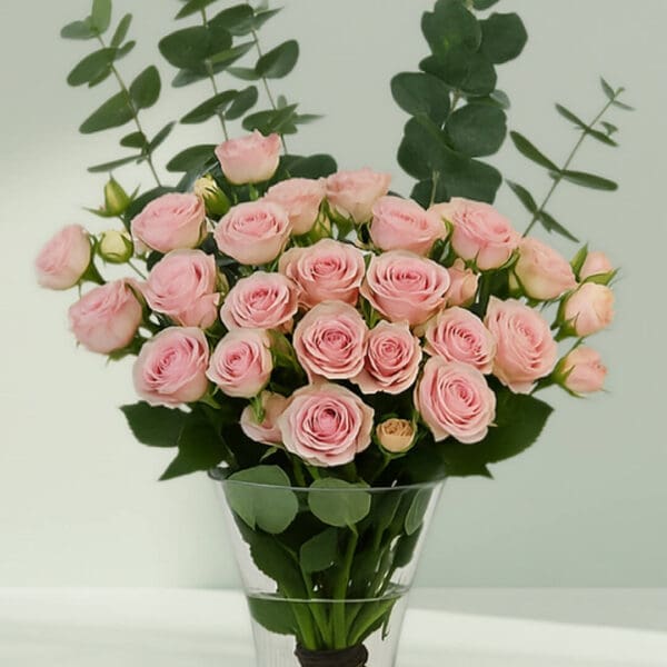 A bunch of romantic rose and eucalyptus in a glass vase