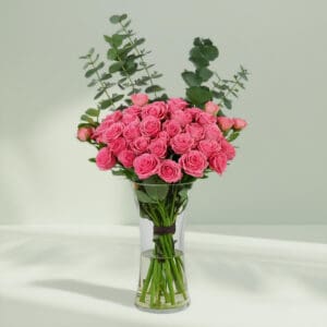 A bunch of Pink roses and eucalyptus in glass vase