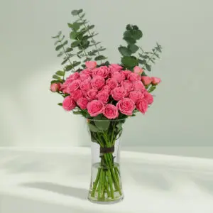 A bunch of Pink roses and eucalyptus in glass vase