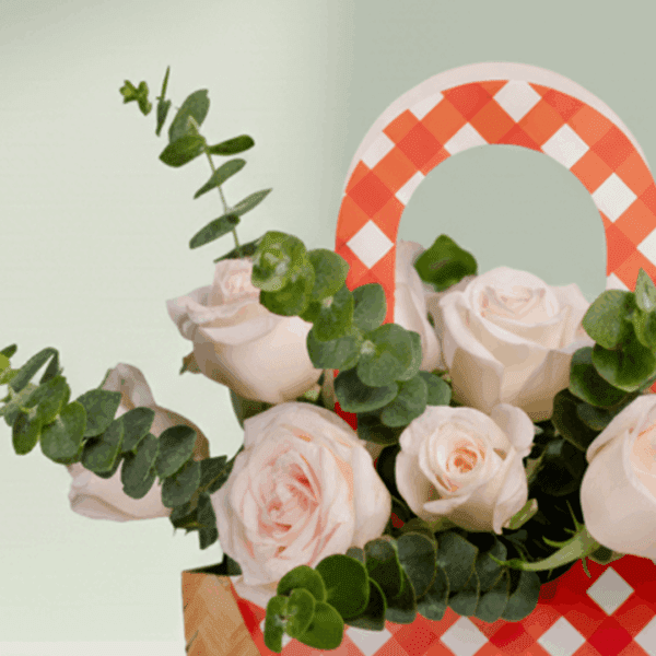 A cute cane paper bag with pink roses and eucalyptus