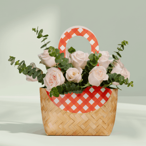 A cute cane paper bag with pink roses and eucalyptus