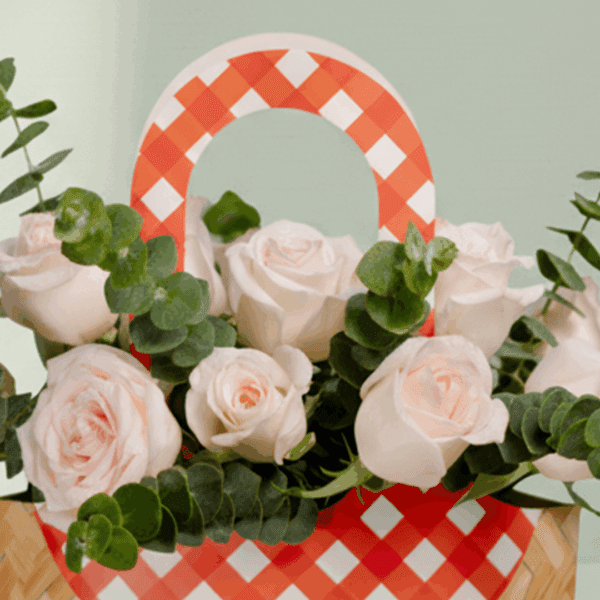 A cute cane paper bag with pink roses and eucalyptus