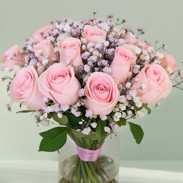 A bunch of elegant pink roses arranged in a transparent glass vase