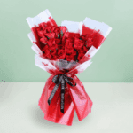 Stunning red roses beautifully arranged with green leaves in Korean flower sheets, tied with a sleek black ribbon.