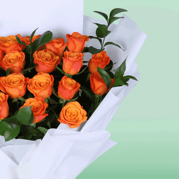 Hand-tied orange rose flower bouquet styled with white wrapping and printed message card saying 'thinking of you'