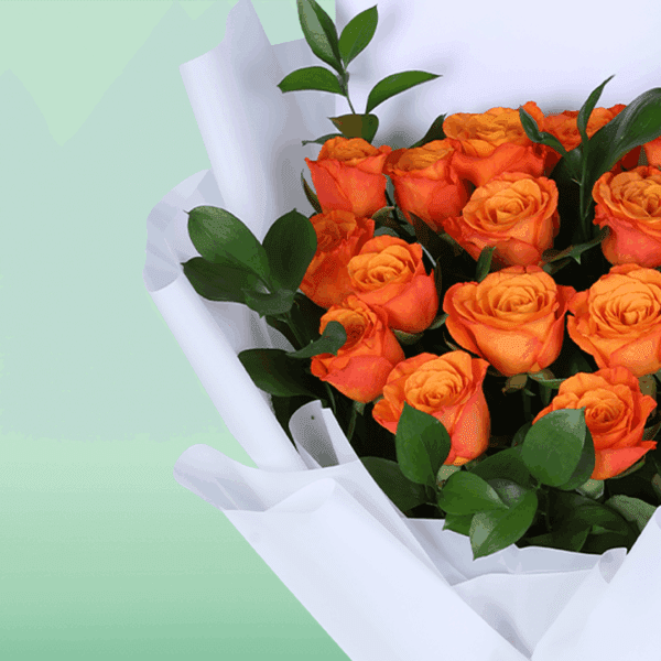 Hand-tied orange rose flower bouquet styled with white wrapping and printed message card saying 'thinking of you'