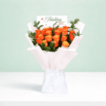 Hand-tied orange rose flower bouquet styled with white wrapping and printed message card saying 'thinking of you'