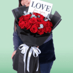 Premium red roses and eucalyptus arrangement in black wrapping with a “Love For You” card