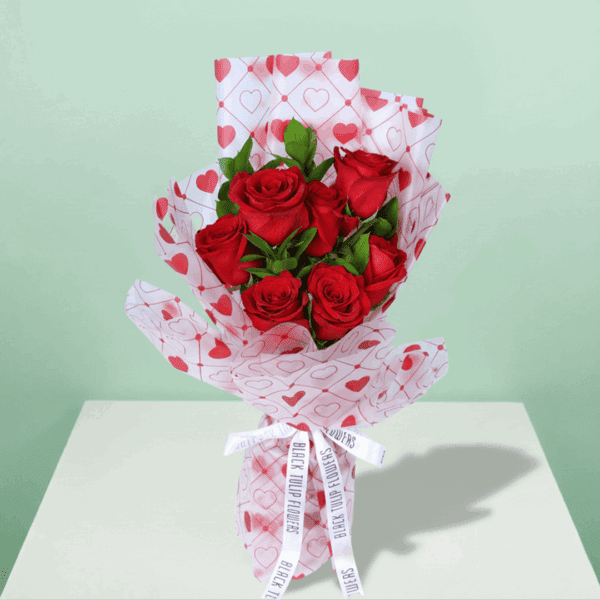 Romantic red rose bouquet with fresh green leaves, wrapped in elegant Korean-style flower sheets
