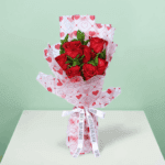 Romantic red rose bouquet with fresh green leaves, wrapped in elegant Korean-style flower sheets
