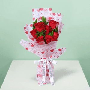 Romantic red rose bouquet with fresh green leaves, wrapped in elegant Korean-style flower sheets