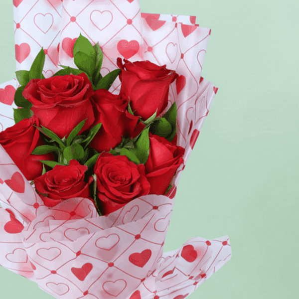 Romantic red rose bouquet with fresh green leaves, wrapped in elegant Korean-style flower sheets