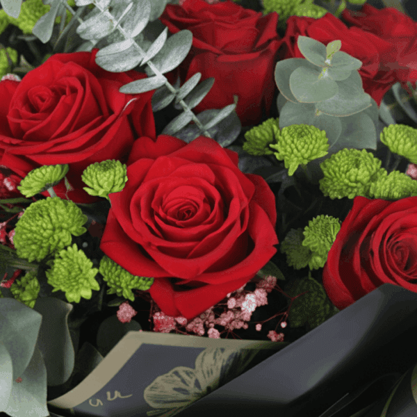 Red mixed flower bouquet with roses, chrysanthemums and eucalyptus wrapped in Korean style sheets with golden "Love You" topper