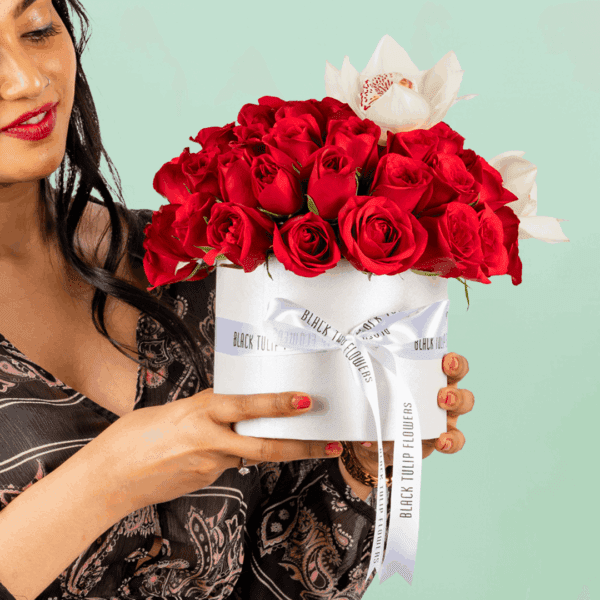 50 red and white roses with Cymbidium arranged in a white round box and tied with a whte satin ribbon