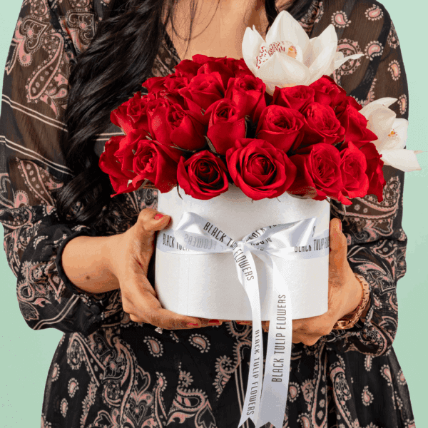 50 red and white roses with Cymbidium arranged in a white round box and tied with a whte satin ribbon