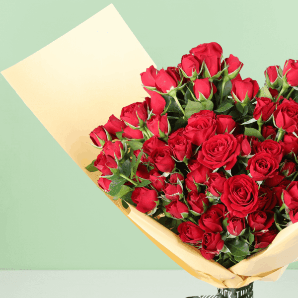 A luxurious arrangement of vibrant red roses, beautifully gathered and wrapped in non-woven paper.