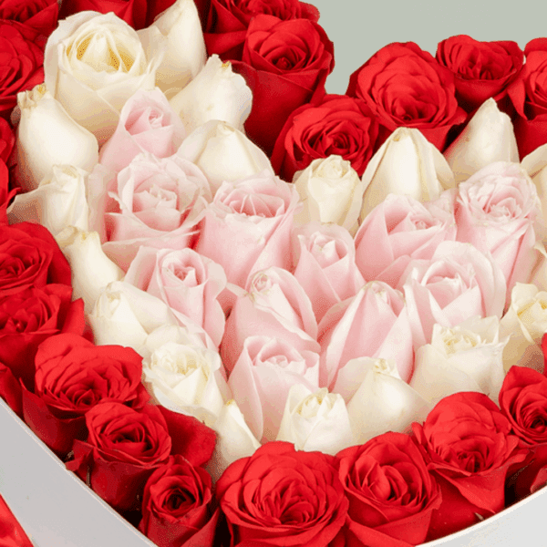 White heart-shaped box with 50–55 assorted roses and a Valentine topper