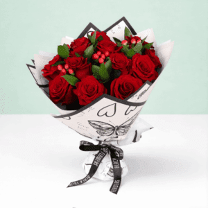 Mixed red floral bouquet with roses, hypericum, and green leaves, styled in trendy Korean wrapping.
