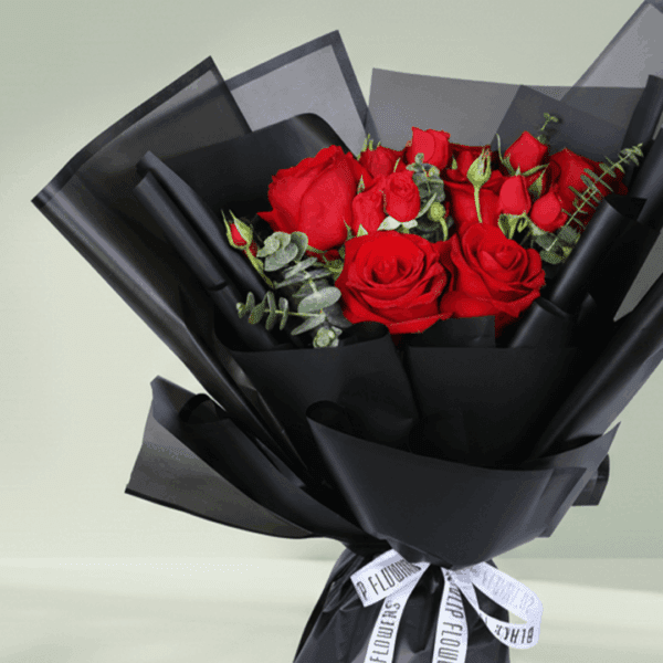 "Red roses with delicate spray roses and eucalyptus, wrapped in elegant black Korean-style flower sheets"