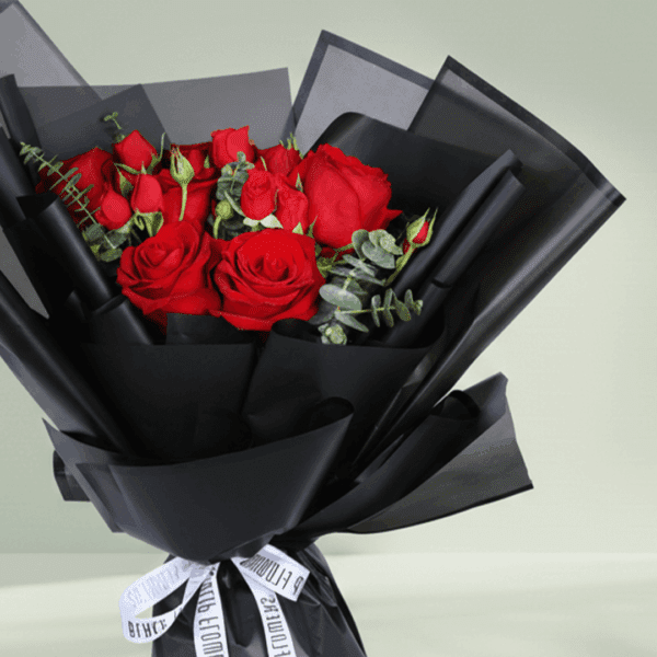 "Red roses with delicate spray roses and eucalyptus, wrapped in elegant black Korean-style flower sheets"