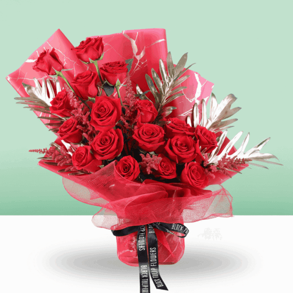 A luxurious bouquet of deep red roses, wrapped in red Korean-style floral sheets, tied with a black ribbon.