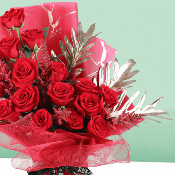 A luxurious bouquet of deep red roses, wrapped in red Korean-style floral sheets, tied with a black ribbon.