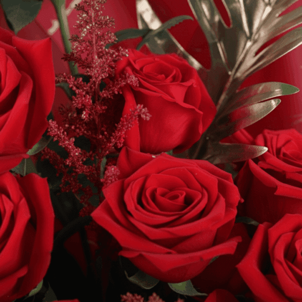 A luxurious bouquet of deep red roses, wrapped in red Korean-style floral sheets, tied with a black ribbon.