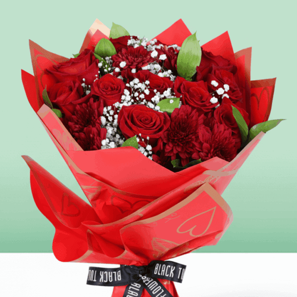 "Romantic red floral arrangement with roses, chrysanthemums, green leaves, and a golden “Love You” topper in Korean wrapping. "