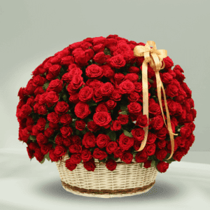 An overflowing arrangement of red roses in a white wicker basket, finished with a gold ribbon.