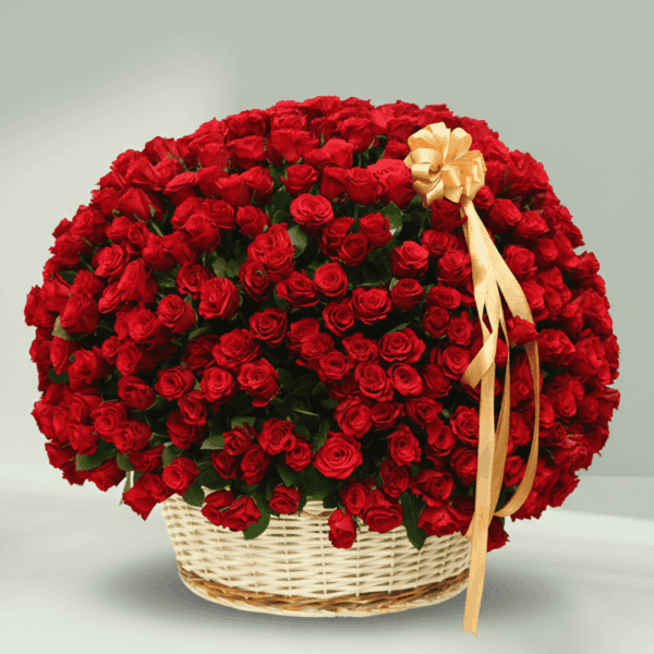An overflowing arrangement of red roses in a white wicker basket, finished with a gold ribbon.