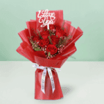 "Fifty red roses arranged elegantly, wrapped in Korean-style flower sheets and topped with a “Love You” sign"