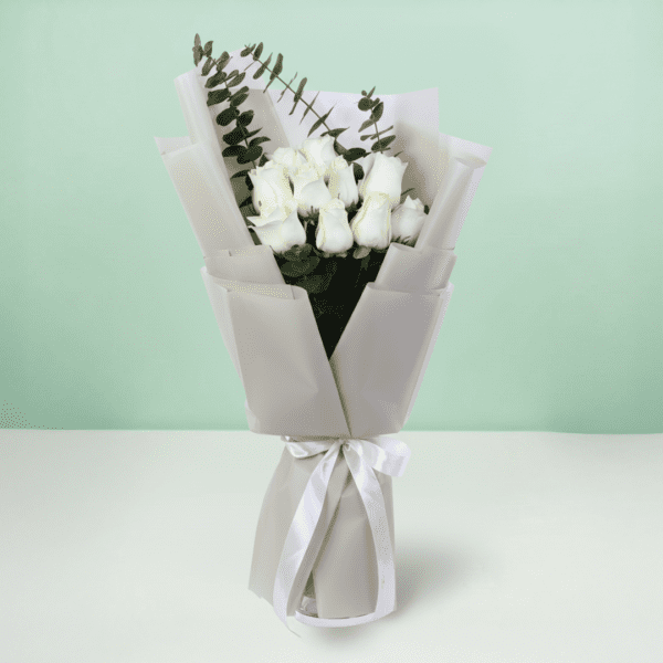 A bouquet of white roses and eucalyptus in a soft white wrap.