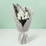 A bouquet of white roses and eucalyptus in a soft white wrap.
